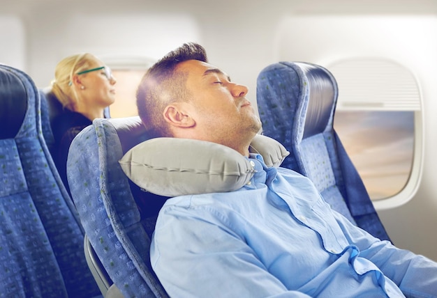 Photo man sleeping in plane with cervical neck pillow