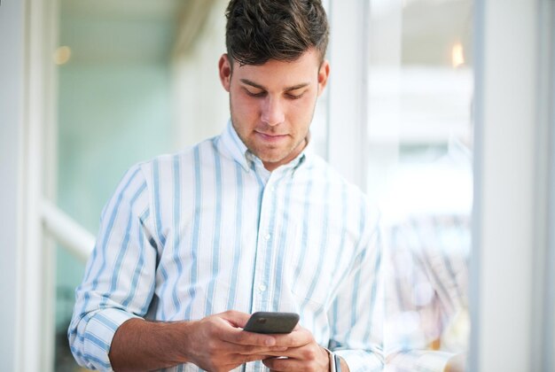 Photo man smartphone and reading at startup office and texting with email notification for networking at company person phone and click for contact communication and app at creative agency in spain