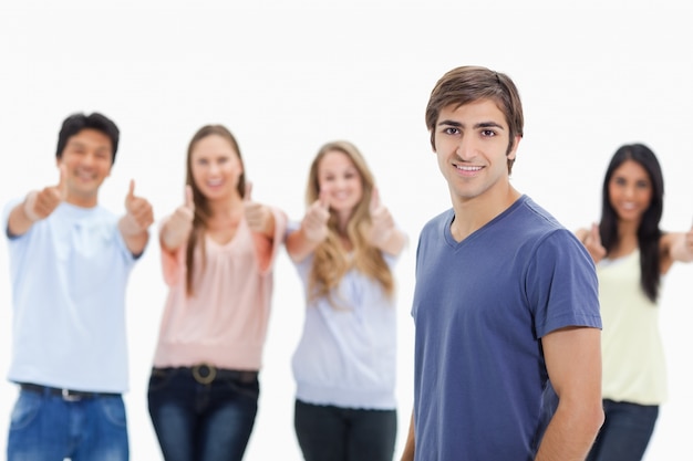 Man smiling with people approving behind him