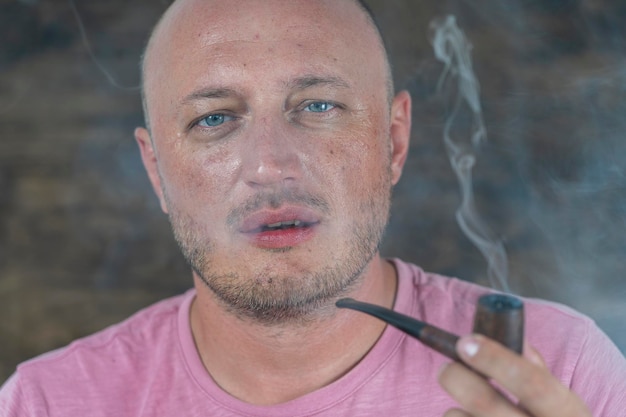 Man smoking pipe Portrait of middle aged man indoors Bad habits addiction