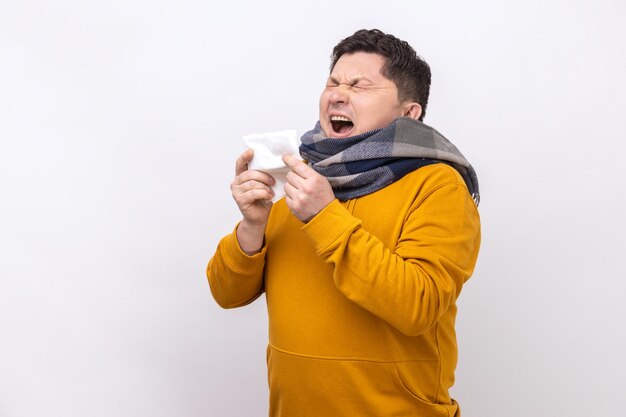 Man sneezing in napkin cleaning running nose and coughing suffering influenza symptoms