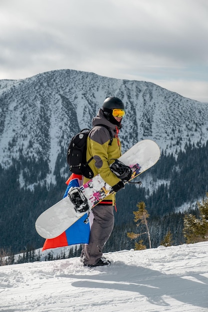 Man snowboarder with slovakia flag at ski resort slope