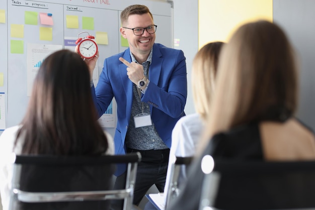 Man speech giver stand in from of colleagues and explain that time is money