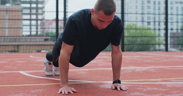 Man in sportswear doing pushup exercise on basketball court Healthy Lifestyle and Sport Concept