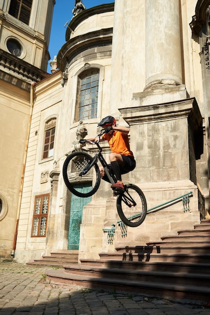 Man in sportswear jumping from steps on a bicycle