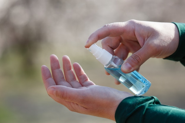 Man spraying hand sanitizer on hand