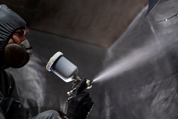 Man spraying powder paint  low angle