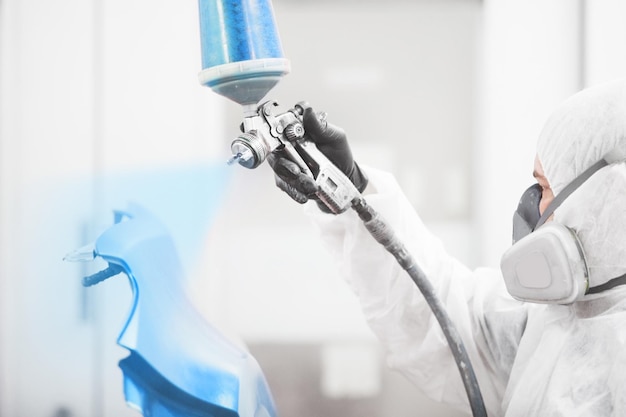 Man sprays blue dye on the elements of the vehicle