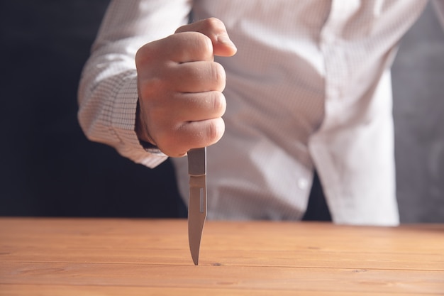 The man stabbed the table .