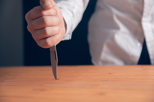 The man stabbed the table .