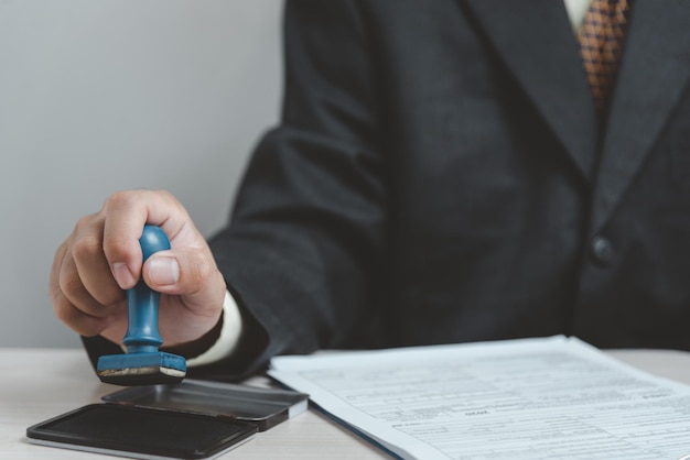 Man stamping approval of work finance banking or investment marketing documents on desk