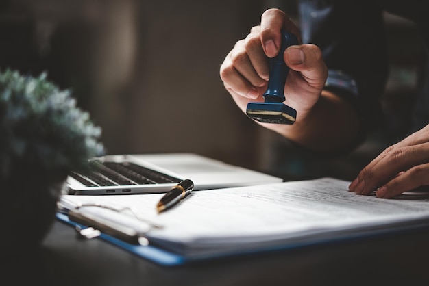 Man stamping approval of work finance banking or investment marketing documents on desk