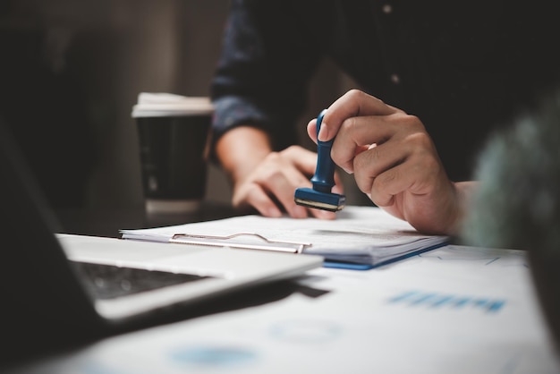 Man stamping approval of work finance banking or investment marketing documents on desk