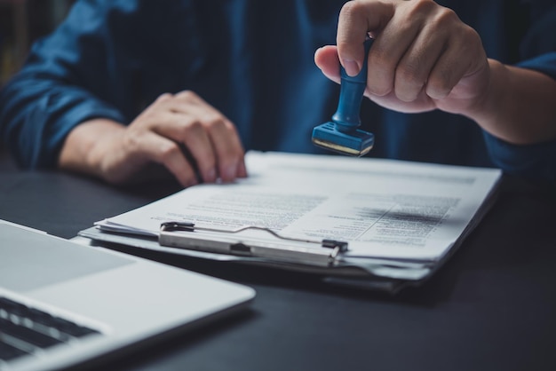 Man stamping approval of work finance banking or investment marketing documents on desk