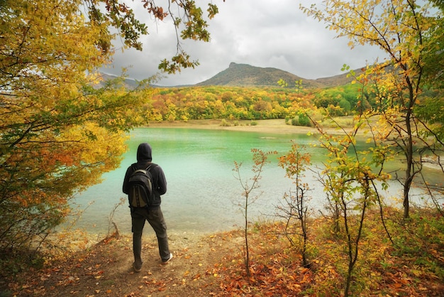 Man standing alone on the autumn pond