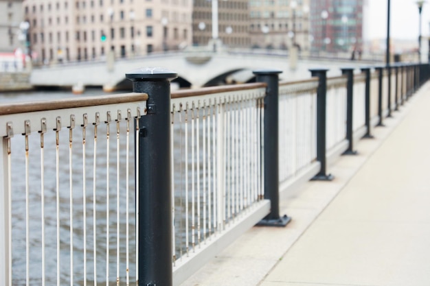 A man standing next to a fence that has a sign that says " i love you " on it.