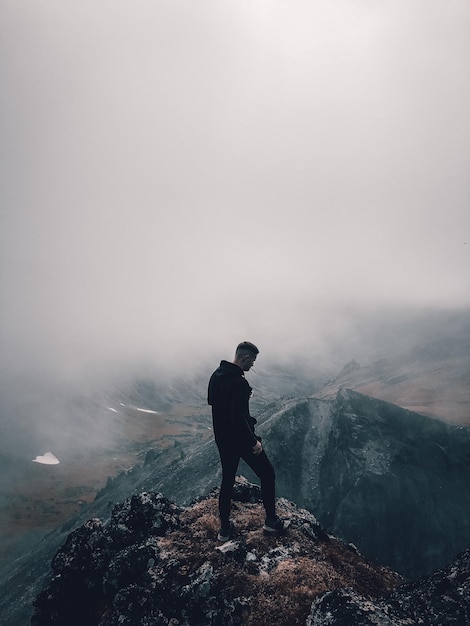 Photo man standing on mountain against sky