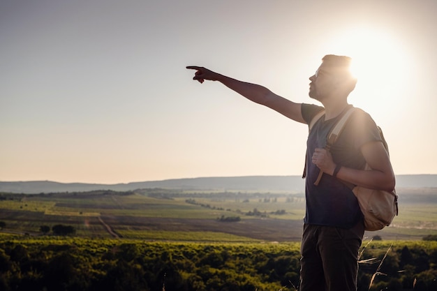 A man standing on a mountain as the sun sets