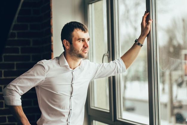 The man standing near the panoramic window Hand on window Stay at home during quarrantine