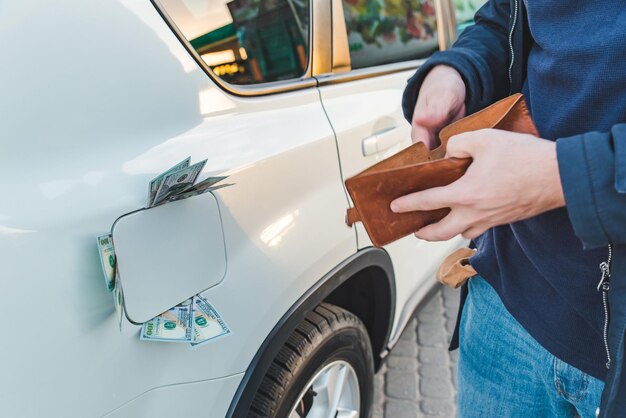 man standing with empty wallet dollars money in car tank gas station concept