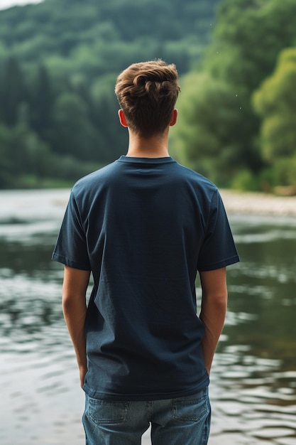 Photo a man stands in front of a lake with his back to the camera