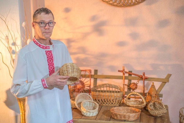 A man stands in front of a shelf of wicker baskets.