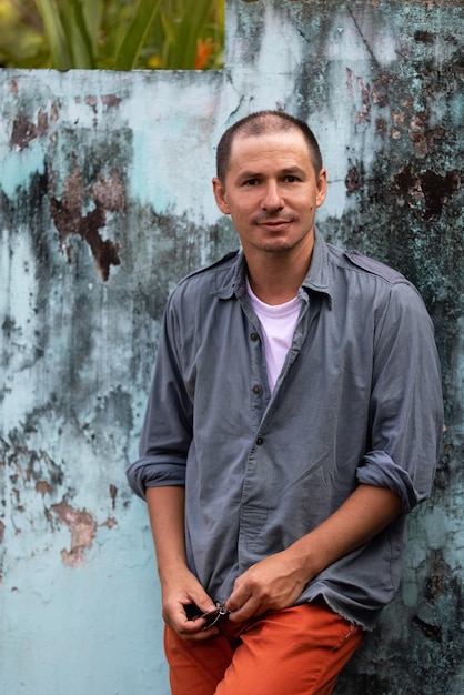 A man stands in front of a wall that has been painted blue.