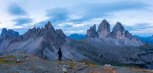 Photo a man stands on a mountain top with mountains in the background