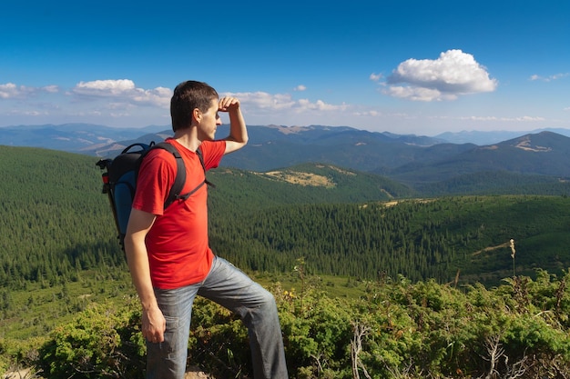 Man stands on a peak of mountains and looking the scenery