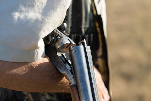 A man stands with weapons and hunting dogs tracking down the game