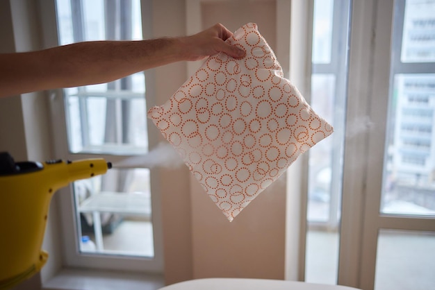 Man steaming pillow at home closeup view