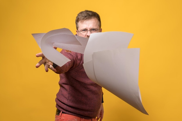 Man in stress and anger throws a stack of white paper forward. Bad working day