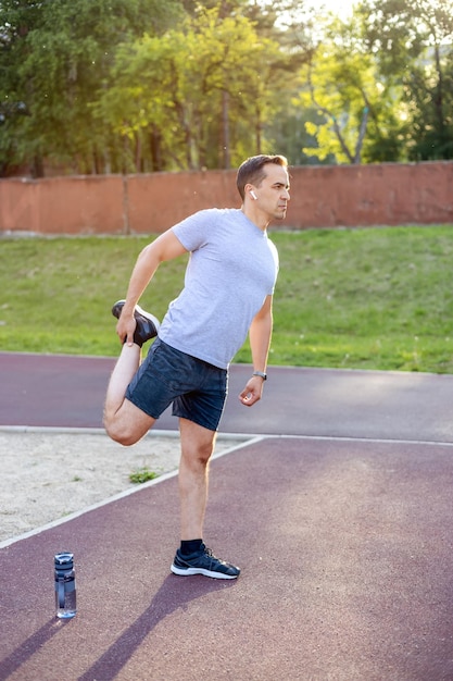 A man stretches the muscles on his leg after an active workout