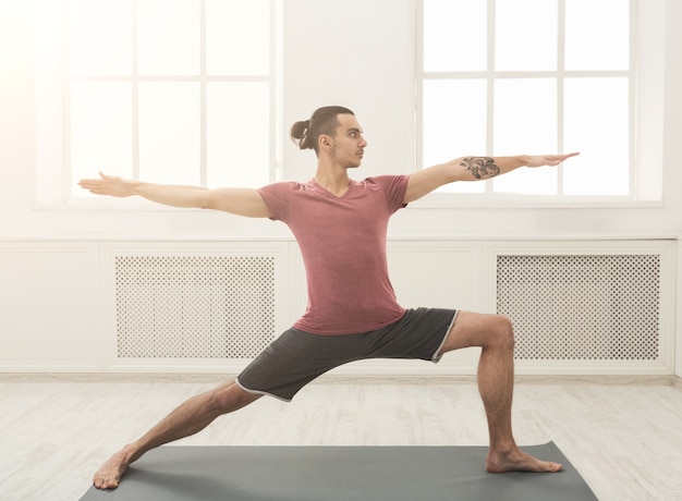 Man stretching hands and legs on mat at gym. Athlete do workout. Sport, yoga, pilates, fitness, healthy lifestyle concept