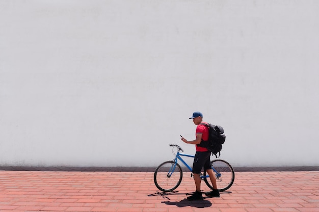 Man Strolling With Bicycle And Watching His Phone