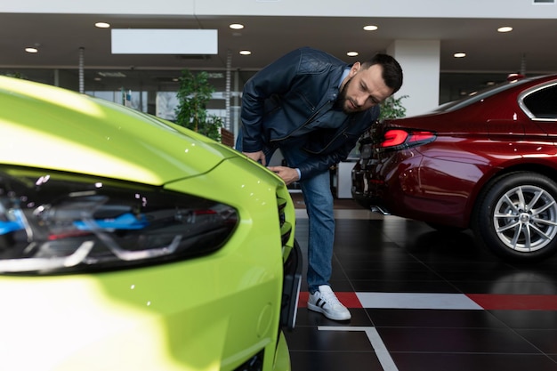 A man studies the technical specifications of a car in a car dealership