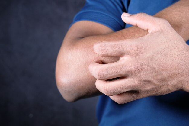 Man suffering from itching skin, close up.