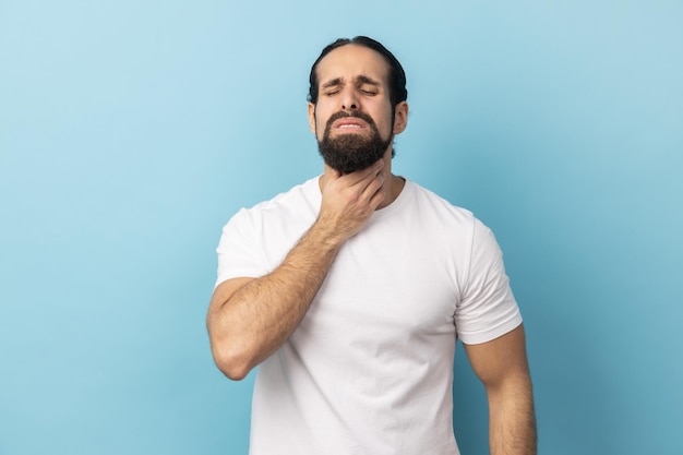 Photo man suffering from sore throat keeping hand on her neck frowning face and closed eyes