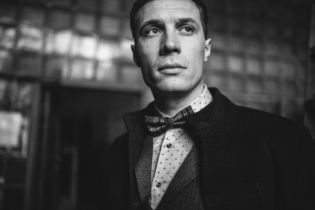 Man in a suit and coat poses in elegant outfit