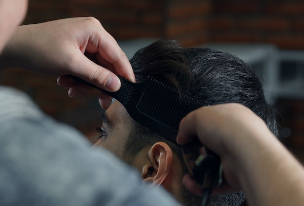 Man in suit getting haircut at barbershop.