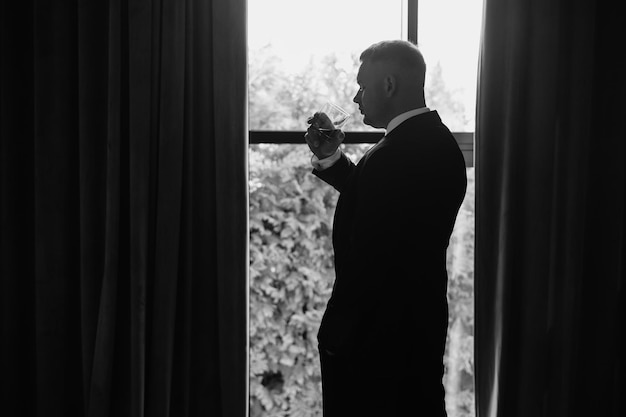 a man in a suit is standing in front of a window with a curtain that says quot no quot