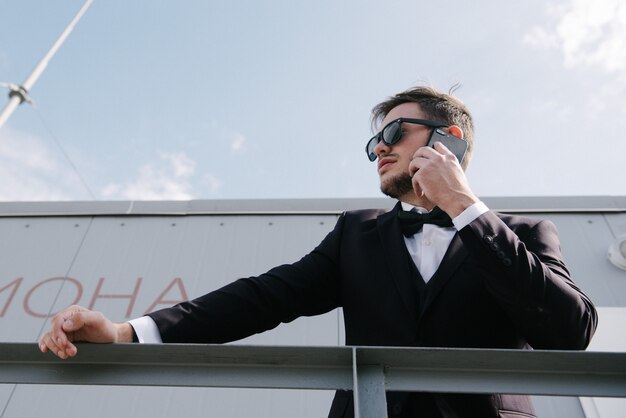 A man in a suit is talking on the phone.