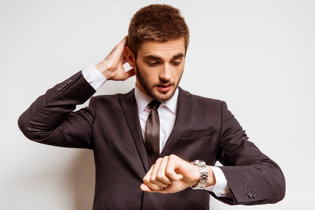 Photo a man in a suit looks at his watch.