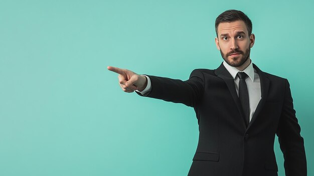 Photo a man in a suit pointing to the left with a blue background