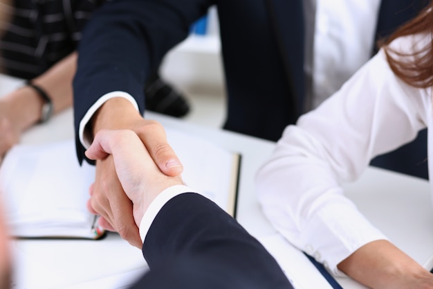 Man in suit shake hand as hello in office closeup