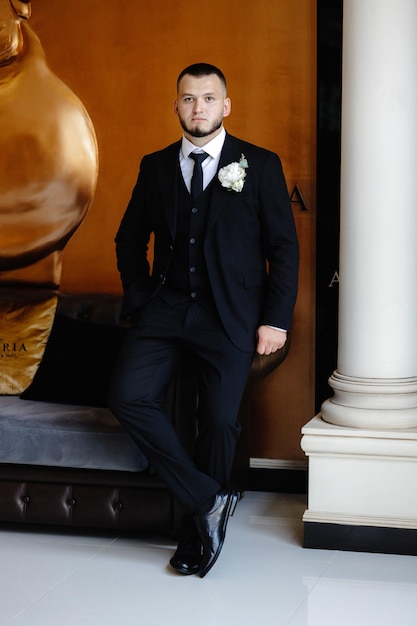 Photo a man in a suit sits in front of a poster that says  la la la la la la la la la