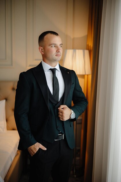 a man in a suit stands in front of a lamp