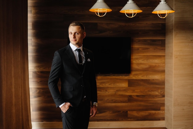 a man in a suit stands in front of a wall with lights on it