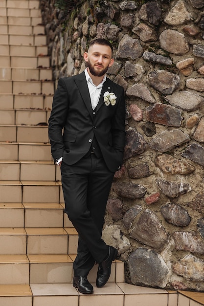 Photo a man in a suit stands on a set of stairs