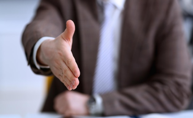 Man in suit and tie give hand as hello